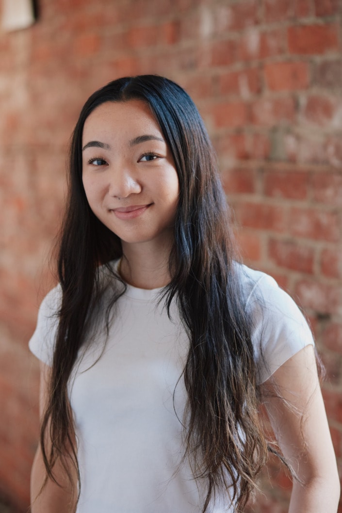 natural light female headshot with red brick background