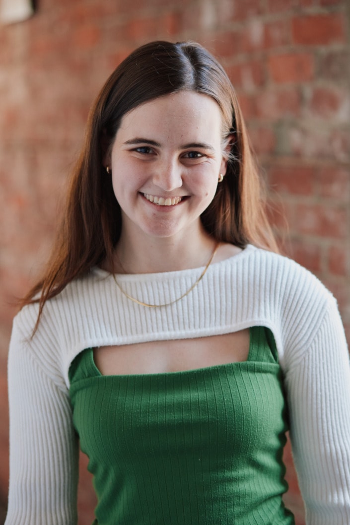 natural light female headshot with red brick background